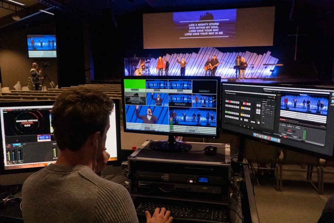 Professional video editing workstation with multiple monitors showing broadcast footage