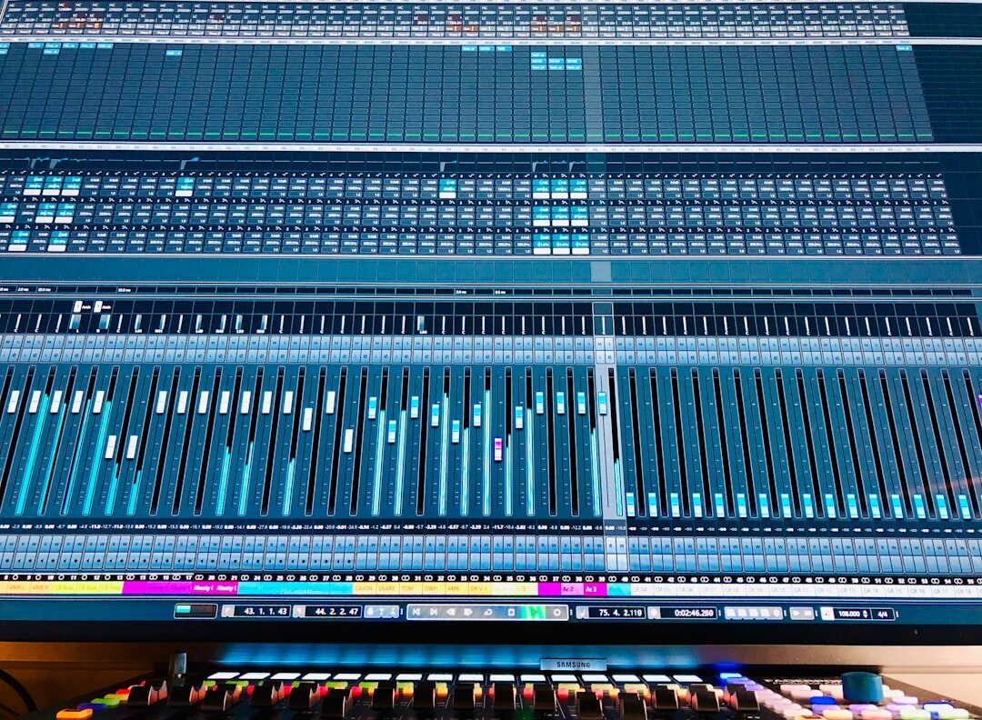 Professional audio mixing console with colorful faders in a recording studio